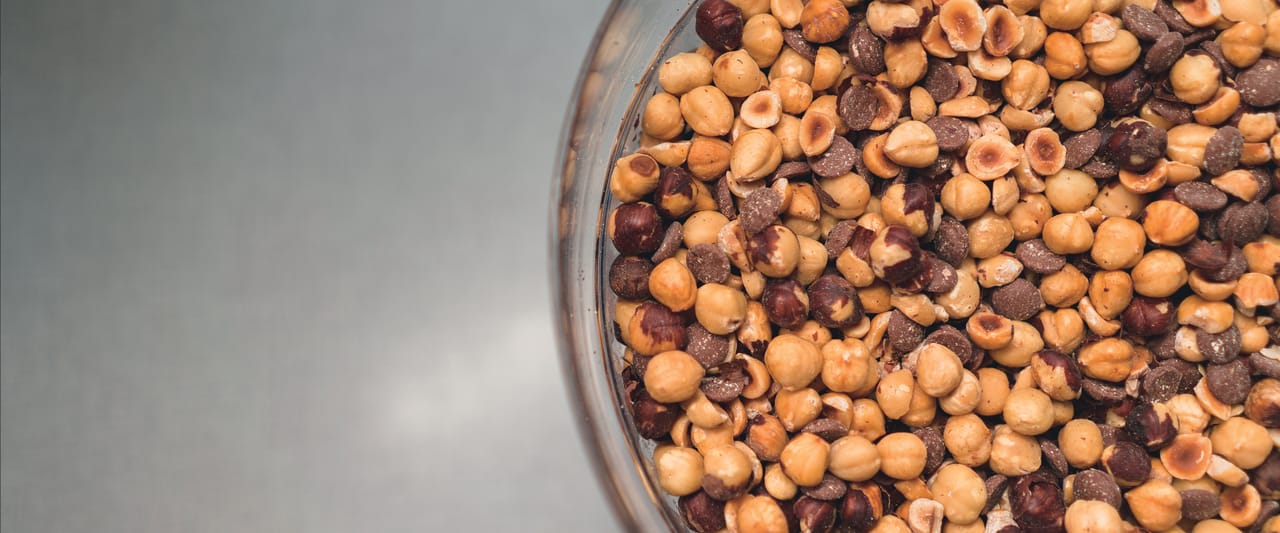 Een mix van hele hazelnoten en andere noten, klaar om te malen